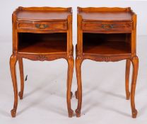 A pair of stained wood bedside stands in