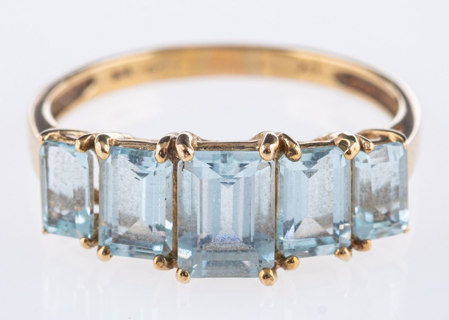 A five stone aquamarine ring, set with graduated step-cut aquamarines, marked 9k, size S, 2.5grams.