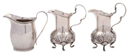 Three silver cream jugs, the Edwardian pair by E. S. Barnsley & Co.