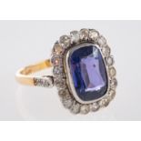 A cluster ring, bezel & milgrain set to the centre with a rectangular mixed-cut purple sapphire,