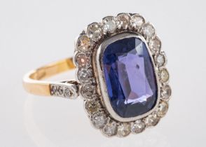 A cluster ring, bezel & milgrain set to the centre with a rectangular mixed-cut purple sapphire,