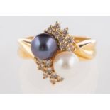 A pearl and diamond ring, set with a white and black cultured pearl and brilliant-cut diamonds,