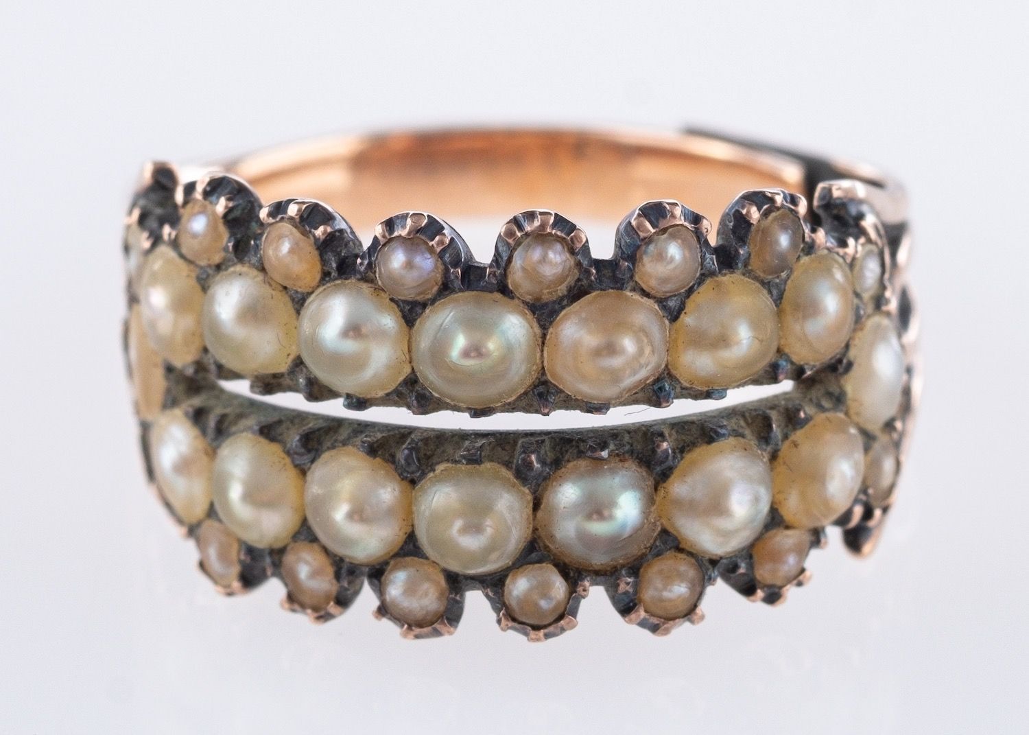A Georgian mourning ring, an openwork setting with four rows of seed pearls, (one missing),