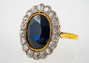 A cluster ring, set centrally with an oval cut dark blue sapphire, sapphire approx. 6.