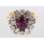 An 18ct yellow & white gold diamond and ruby cluster ring, set centrally with an oval-cut ruby,