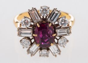 An 18ct yellow & white gold diamond and ruby cluster ring, set centrally with an oval-cut ruby,