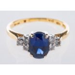 An 18ct yellow & white gold ring, set to the centre with an oval-cut synthetic sapphire,