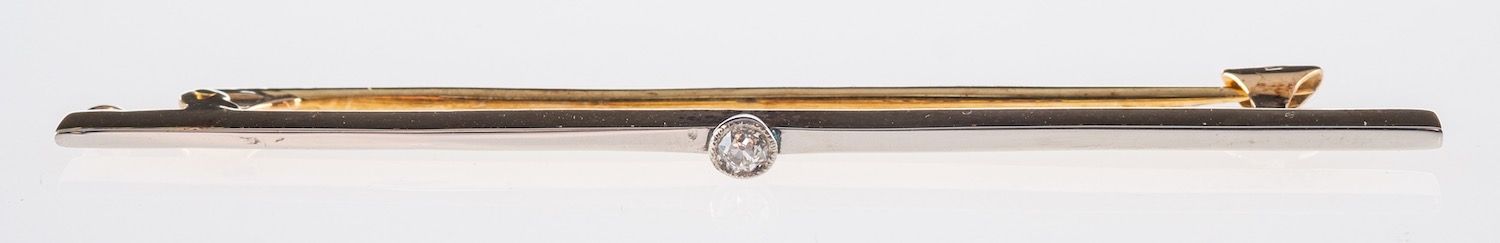 A bar brooch, milgrain set with an old-cut diamond, marked 15ct, length approx. 5.8cm, 3.7grams.