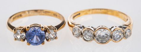 Two 9ct yellow gold rings, a three stone ring set with circular-cut blue and white paste stones,