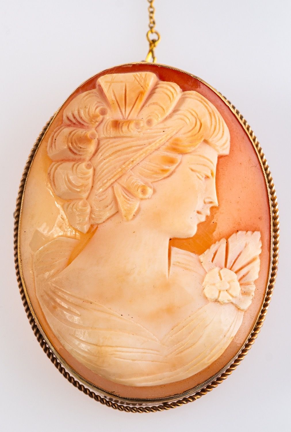 A 9ct yellow gold oval cameo brooch depicting a female bust with flower, measuring approx. 6.