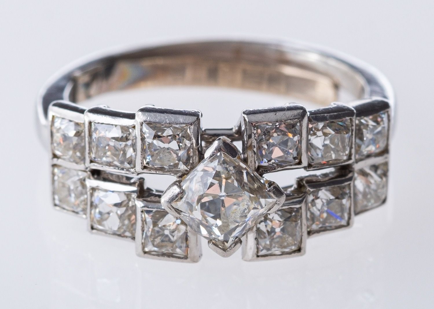 An Art Deco ring, of graduated geometric square design set with old mine-cut diamonds,