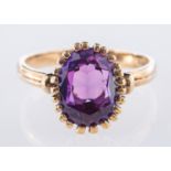 A single stone ring, set with an oval-cut purple stone in a claw setting, marked 9k, size L, 2.