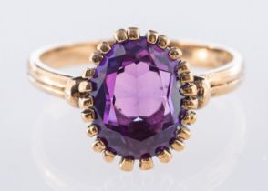 A single stone ring, set with an oval-cut purple stone in a claw setting, marked 9k, size L, 2.