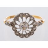 An open-work flowerhead ring, set centrally with an old mine-cut diamond, diamond approx. 0.