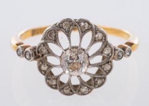 An open-work flowerhead ring, set centrally with an old mine-cut diamond, diamond approx. 0.