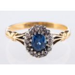 An antique cluster ring, set centrally with an oval-cut sapphire,
