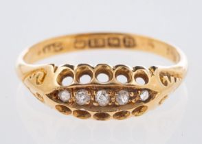 An 18ct yellow gold ring, set with five old-cut diamonds in an open work and scroll setting,