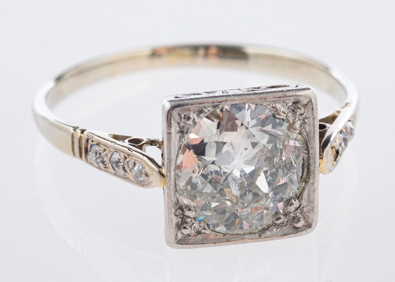 An Art Deco ring, centrally set with an old European cut diamond in a square designed setting,