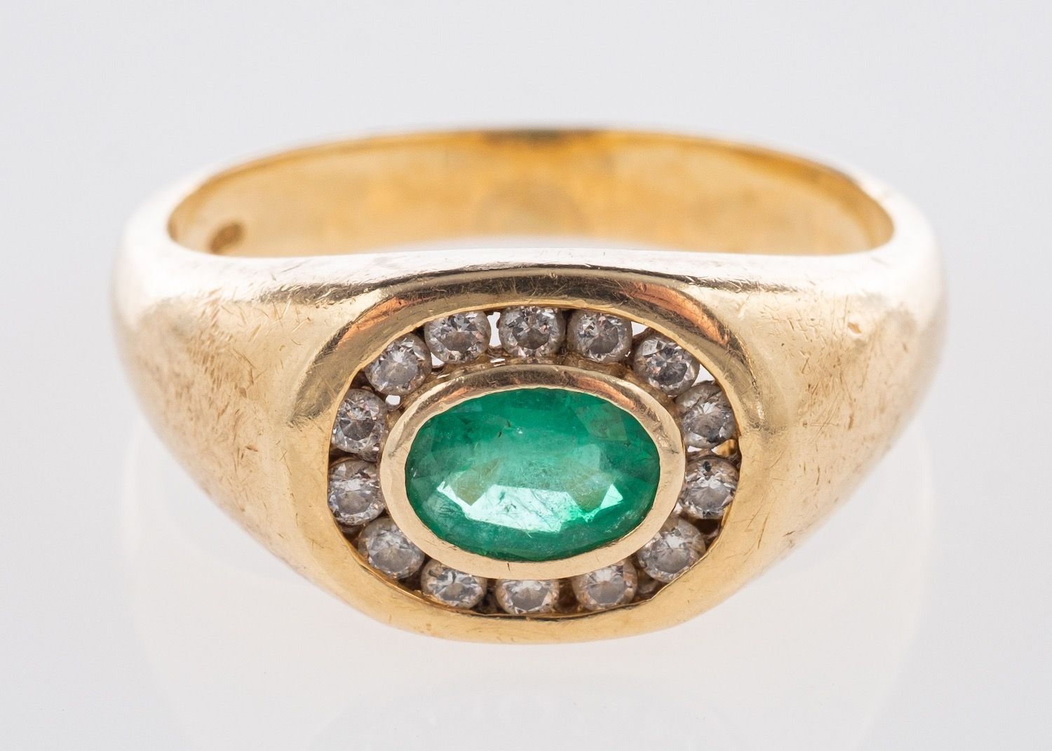 An emerald and diamond ring, a signet style ring set 'east to west' with an oval-cut emerald,