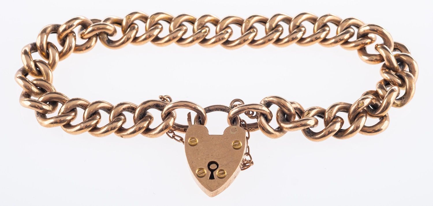 A 9ct yellow gold curb bracelet, with heart padlock and safety chain, marked 9ct, 13.9grams.