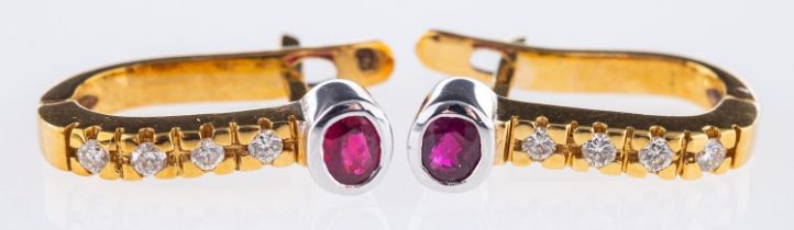 A pair of ruby & diamond earrings, each set with an oval-cut ruby and four brilliant-cut diamonds,