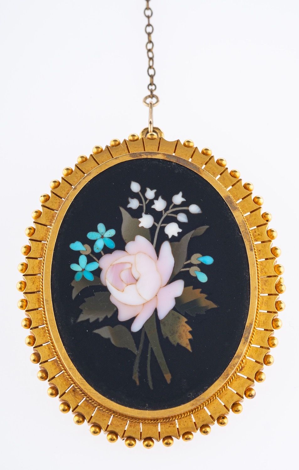 A Pietra Dura brooch, of flower and foliate design with a fancy gilt mount, safety chain,