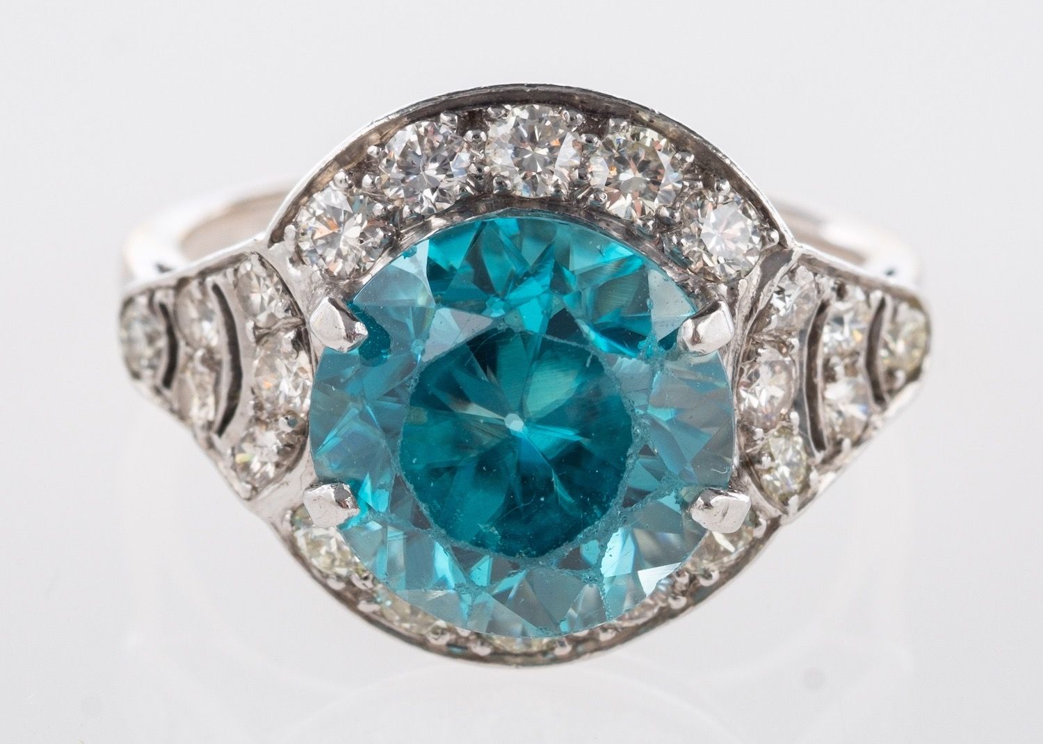 A blue zircon and diamond ring, a cluster style ring set centrally with a circular-cut blue zircon,