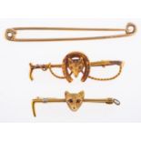 A group of three brooches, including a fox head, horseshoe & riding crop brooch, marked 15ct,