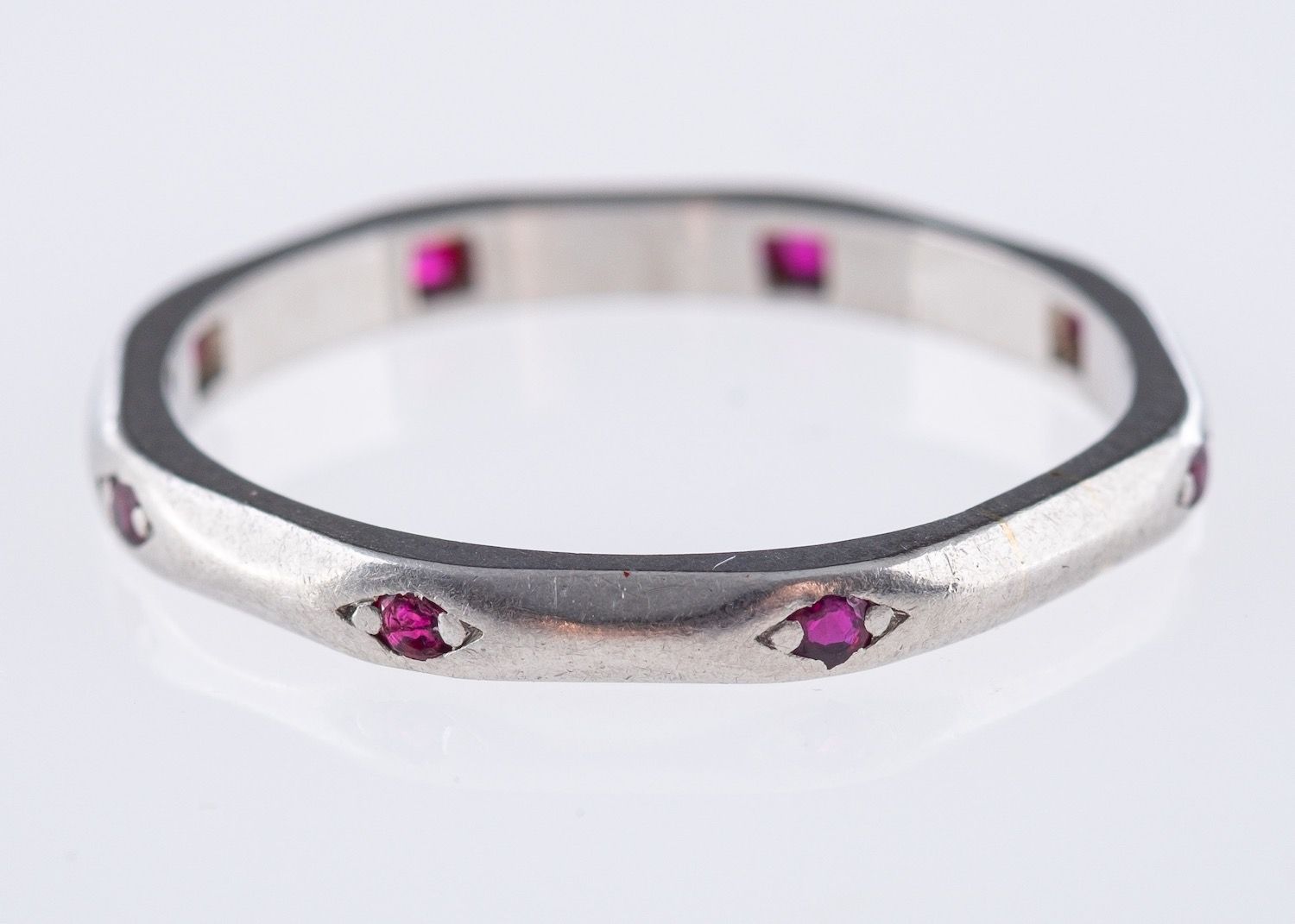 An Art Deco wedding band, of octagonal shape and interspaced with eight circular-cut rubies,