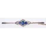 An Edwardian bar brooch, of flowerhead design and set with three oval-cut sapphires,
