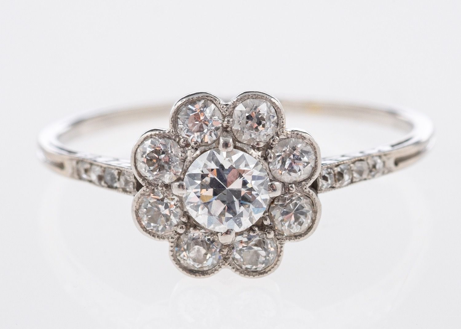 An Art Deco flowerhead ring, milgrain and claw set with old brilliant-cut diamonds,