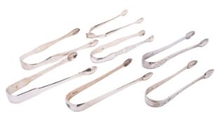 Seven George III silver sugar tongs including: one sprung pivot example with cast beaded arms,