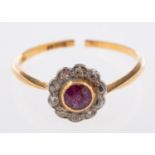 A flowerhead ring, set with a circular-cut ruby, surrounded by single-cut diamonds, marked 18ct,