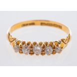 An 18ct yellow gold antique five stone ring, set with graduated old mine-cut diamonds, UK hallmark,