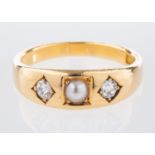 A three stone ring, centrally set with a pearl and an old mine-cut diamond to each side,