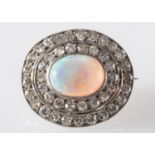 An opal and diamond brooch, set with an oval opal cabochon,