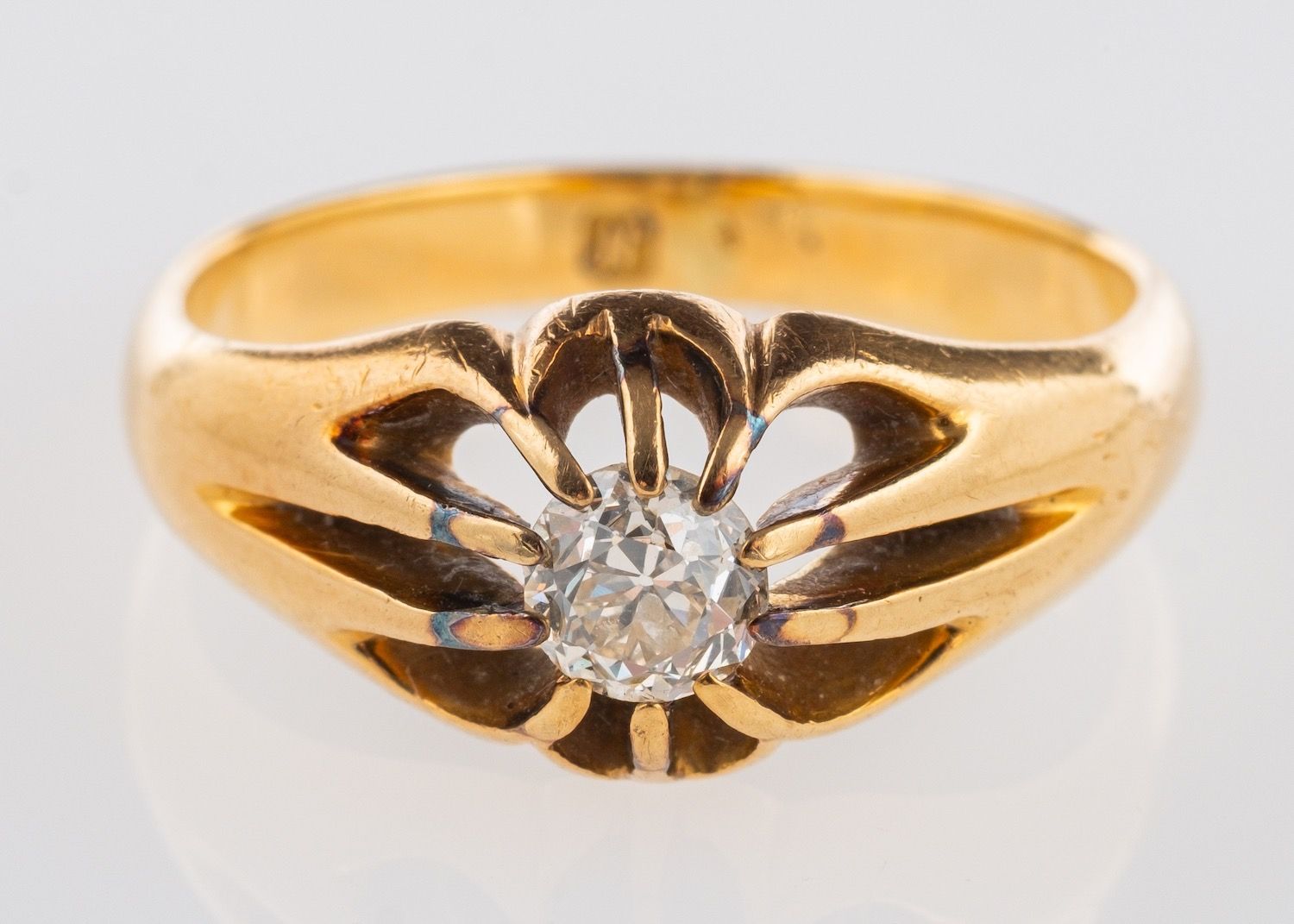 An antique single stone ring, set with an old European-cut diamond in a 'gypsy' style setting,