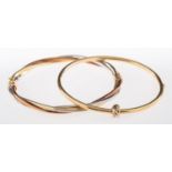 Two gold bangles, a three-coloured twist design bangle, hinged, inner diameter approx 5.