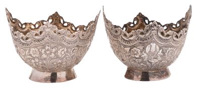 A pair of Indian silver sweetmeat dishes, with a pierced scalloped edge over floral decorated body,