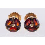 A pair of 9ct yellow gold & garnet stud earrings, each set with three marquise-cut garnets,