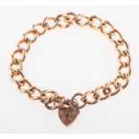 A 9ct rose gold curb bracelet, with heart padlock and safety chain, UK hallmark, length approx. 19.