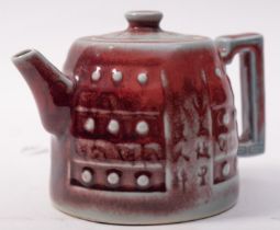 A Chinese copper red glazed teapot and cover, of circular squat form,
