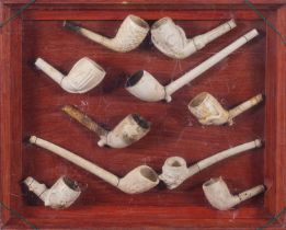A framed collection of ten clay pipe bow