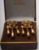 A pair of gold Inca style mask earrings