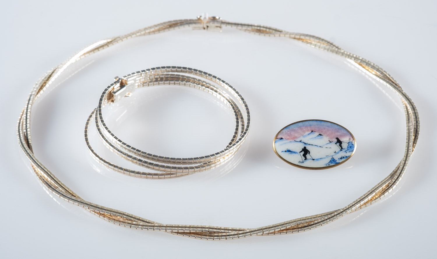 A silver necklet, bracelet and a Norwegi