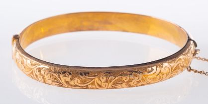 A 9ct gold hinged bangle, with foliate e