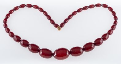 A 1920's red bakelite type necklace, the oval beads graduating in size, length approx. 54.