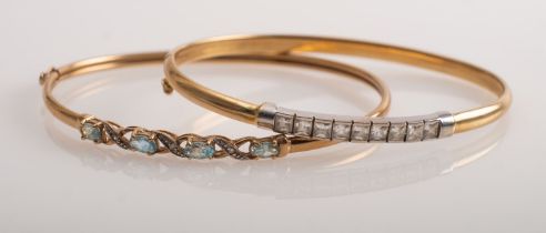 A gold bangle set with blue topaz and a