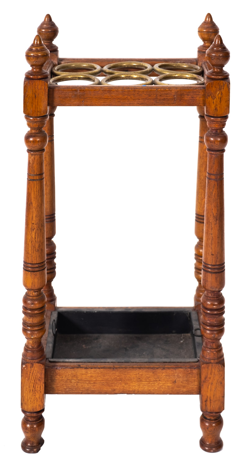 An oak and brass stick stand, circa 1900, with six circular divisions,