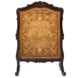 A Victorian carved walnut and Berlin woolwork firescreen, mid 19th Century,